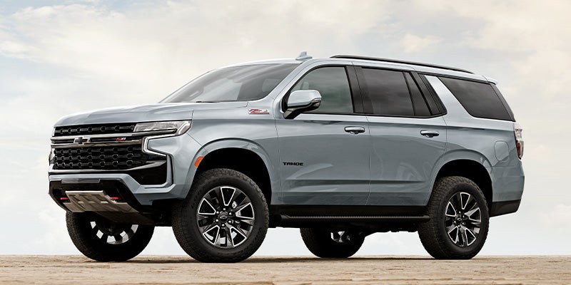 silver 2024 chevy tahoe close up of the front left side driving on a dirt road